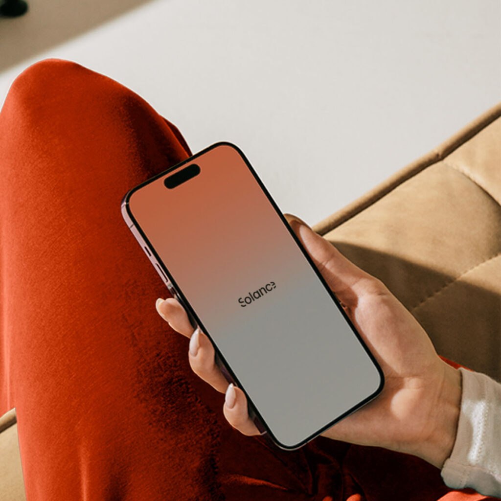Person holding a phone with the Solance app, representing a career opportunity building exceptional financial products